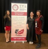 Kamyllie Arteaga-Gutierrez, Megan Milligan, and Simone Billings by a banner at the Awards Ceremony of the 2025 Sigma Tau Delta convention