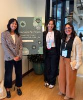 Giselle Laiduc with 2 female faculty colleagues in front of a conference poster