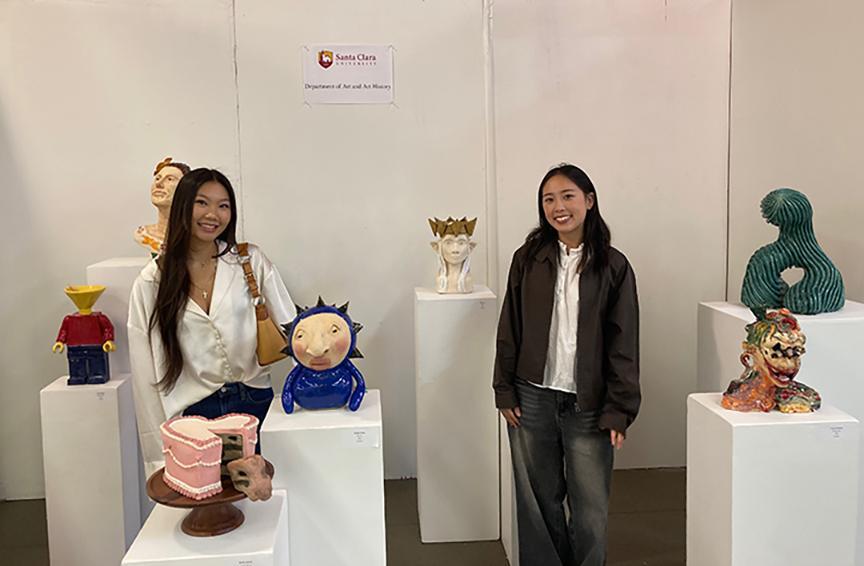 2 female students with their ceramics art exhibition