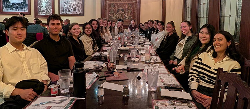 SCU students and faculty seated around a long table at a conference