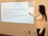 Yujie Ge standing next to her presentation.