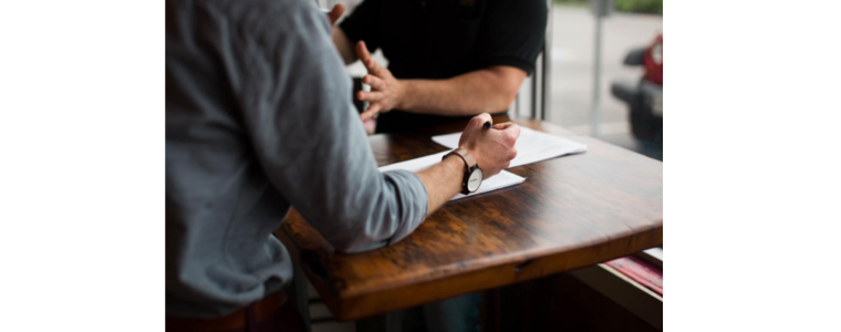 Photo of person's arm while writing on a desk