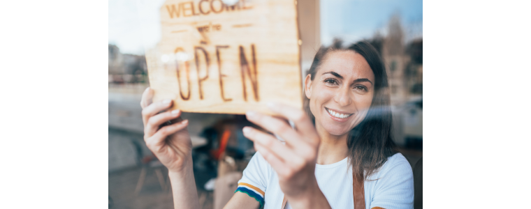 Photo of business owner with an open sign