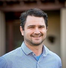 Portrait of a man in a blue shirt.