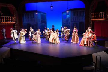 Theater performance of Romeo & Juliet with actors in period costumes on stage.