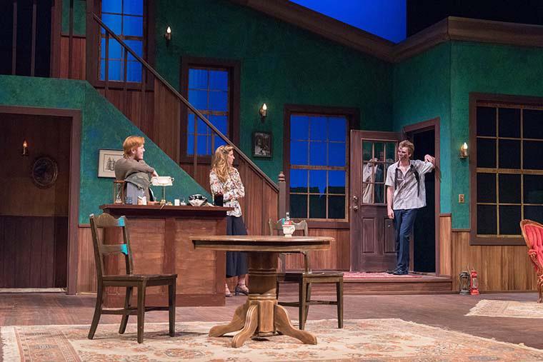 Three actors performing on stage in a living room set for The Foreigner.