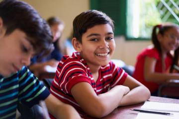 Children sitting at desks in a classroom setting.