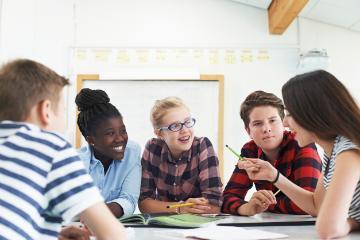 A group of people having a discussion at a table. 