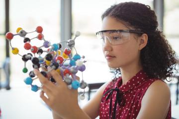 A person examining a colorful molecular model. 
