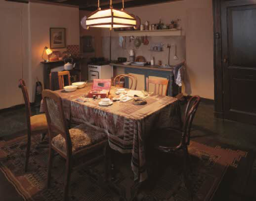 A dimly lit dining room with a table set for dinner.