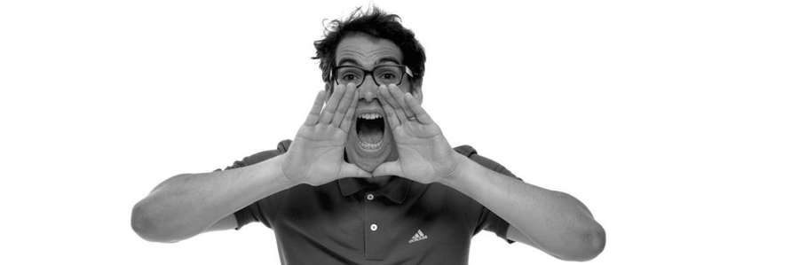 A person making a triangular gesture with hands over their face.