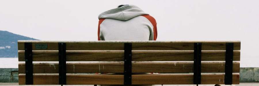 A white arch structure with wooden panels in front of a mountain.