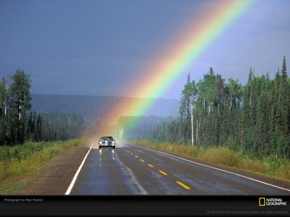 A rainbow that appears to float in between you and a distant mountain