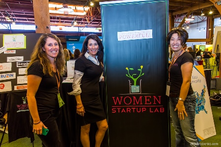 Three women posing in front of a 