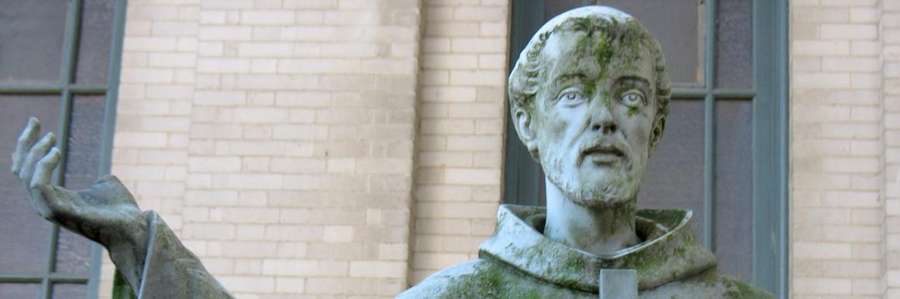 Statue of a robed figure holding an object.