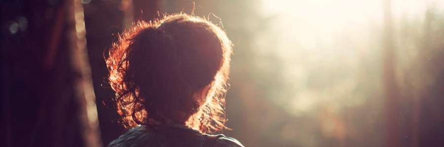 A person facing sunlight, creating a silhouette effect.