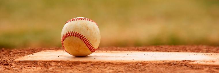 A baseball resting on a pitcher's mound.