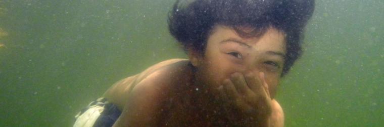 Person underwater with goggles and snorkel.