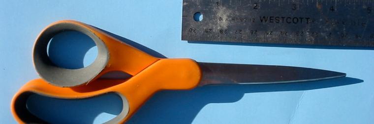 A flashlight casting a long shadow on a blue surface.