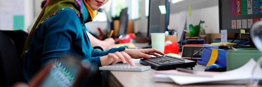 Woman in hijab sitting at a computer at a startup