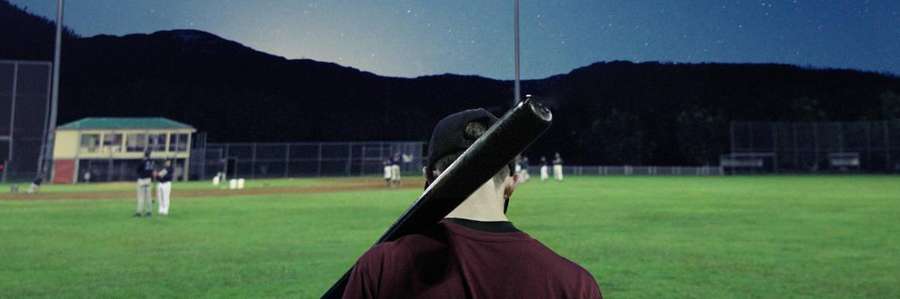 Person taking a photo of a baseball game at night.