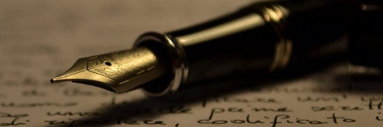 Close-up of a fountain pen nib on a textured surface.