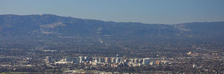 Panoramic view of a city with mountains in the background.